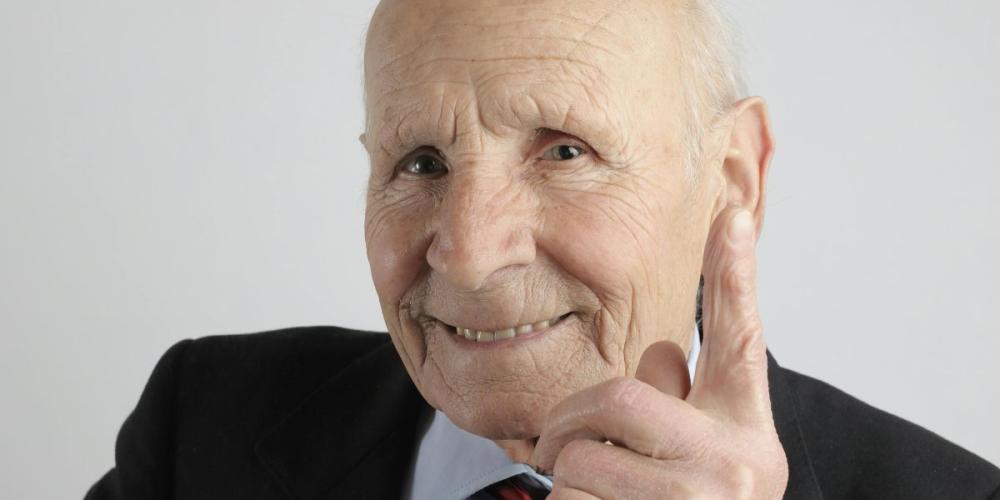 ouderen man steekt glimlachend vingertje op