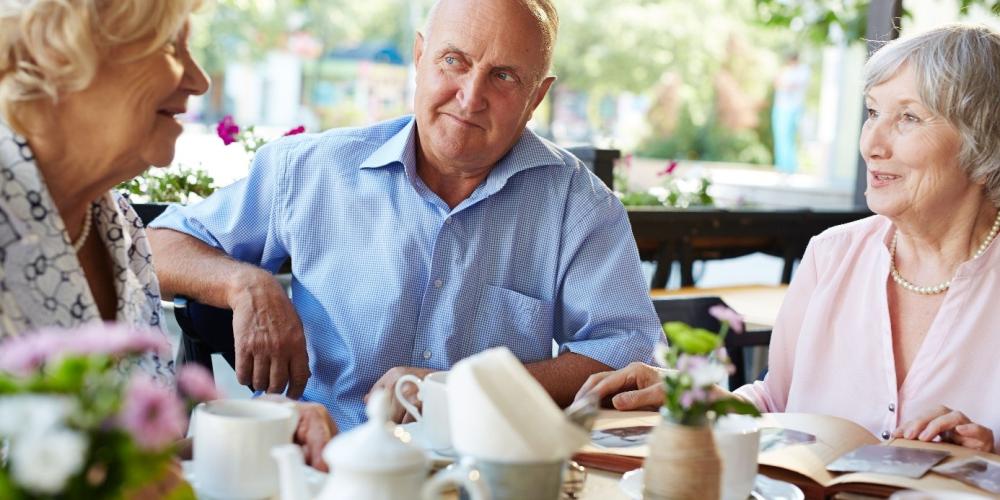 oudere man en dames aan de babbel- en koffietafel