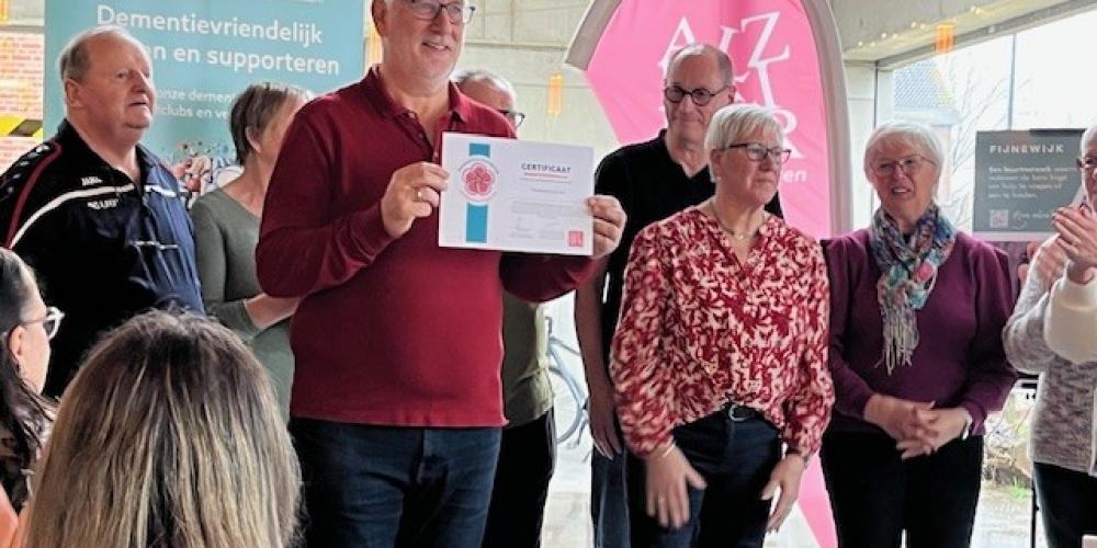 clubafgevaardigde toont certificaat dementievriendelijke sportclub