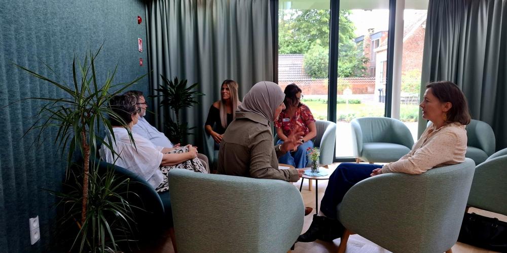 Mensen in comfortabele stoelen en ruimte spreken met elkaar in 