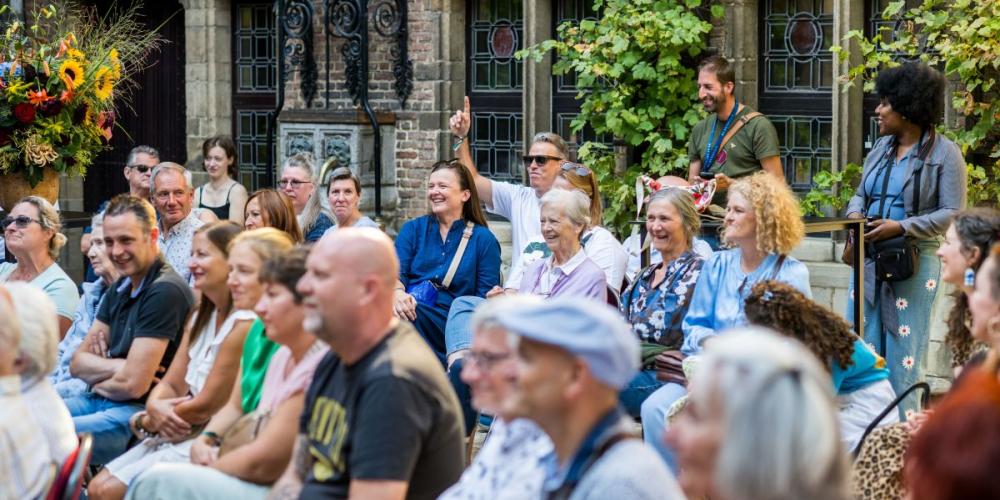iemand in het publiek steekt zijn vinger op om te bieden