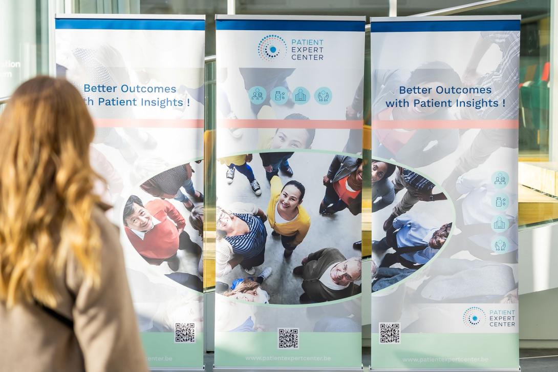 dame kijkt naar banner van patient expert center