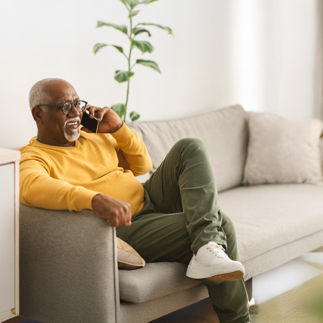 man van middelbare leeftijd belt in de sofa in de woonkamer