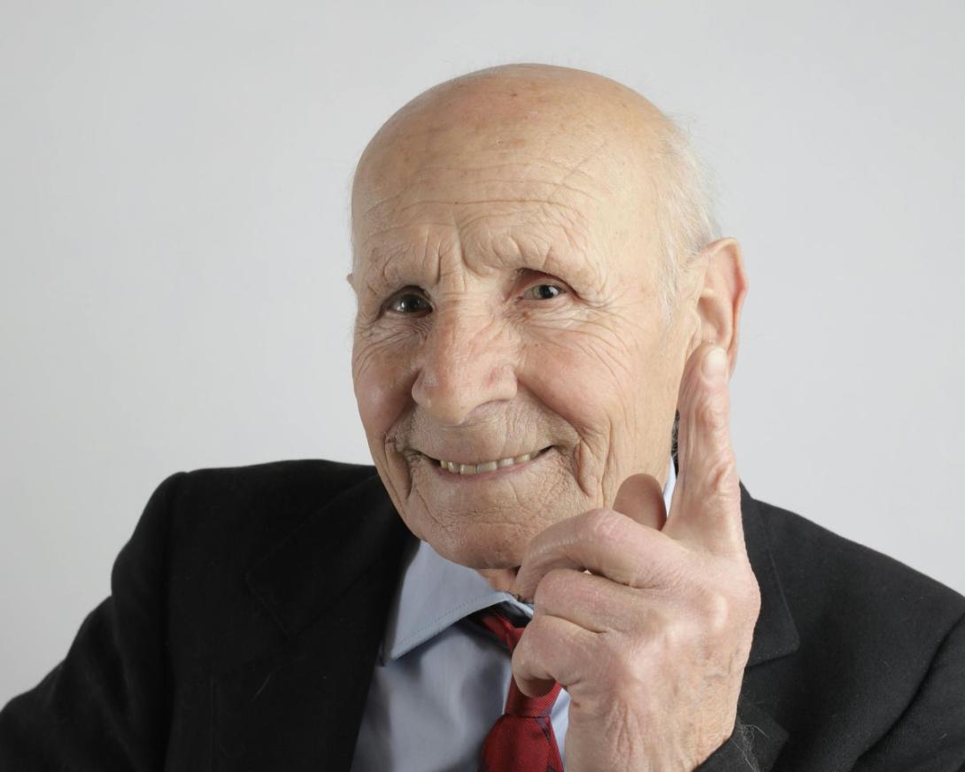 ouderen man steekt glimlachend vingertje op