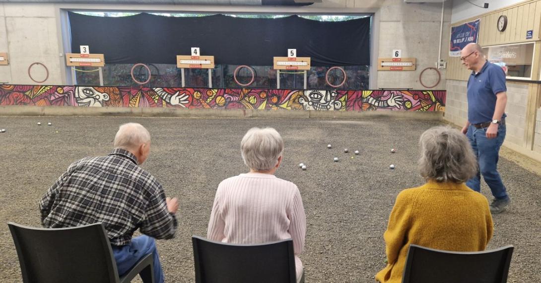 drie zittende petanquespelers