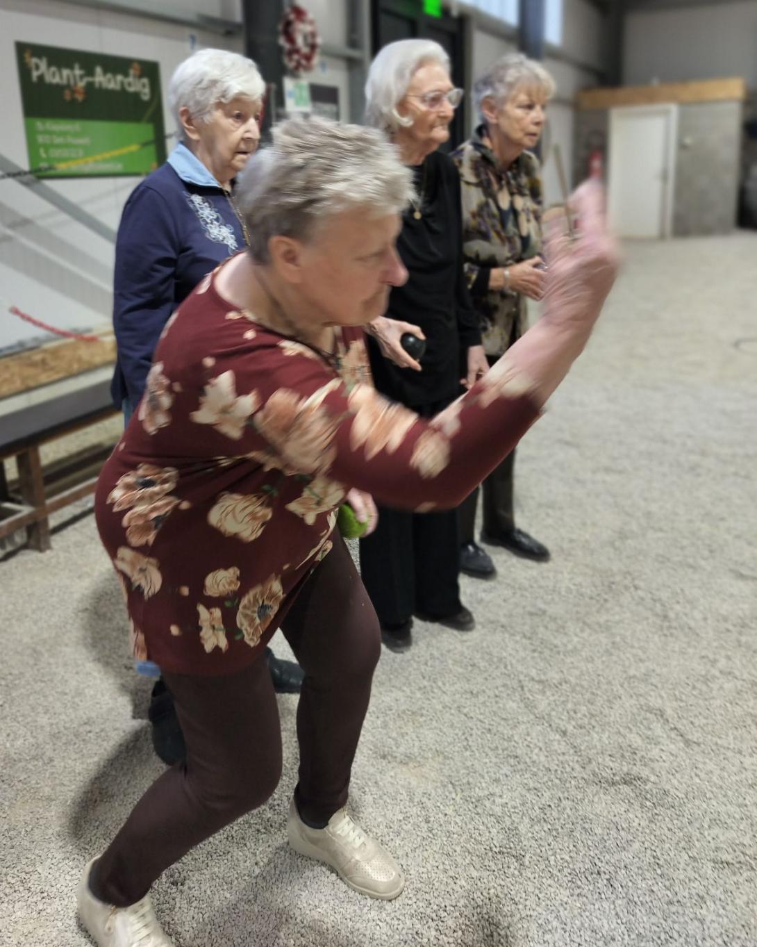 oudere dame speelt petanque in petanquehal Stekene