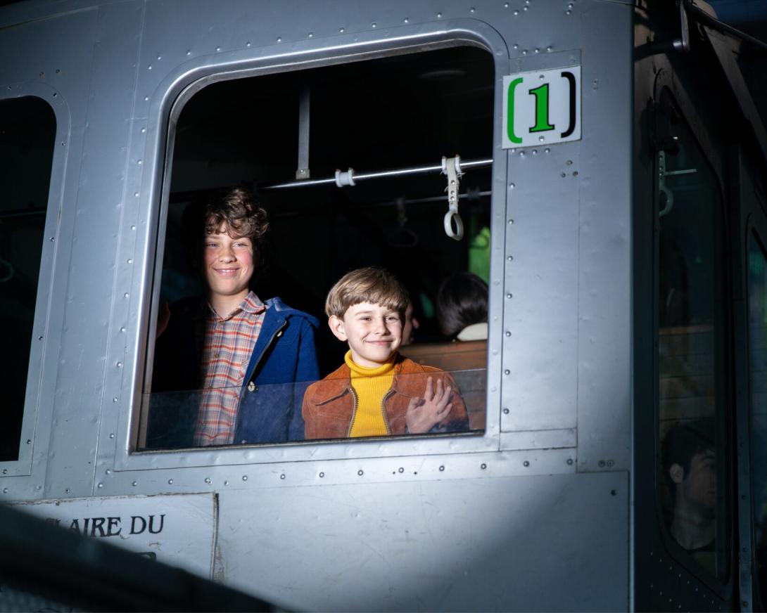 Kinderen kijken door raam trein bij afscheid