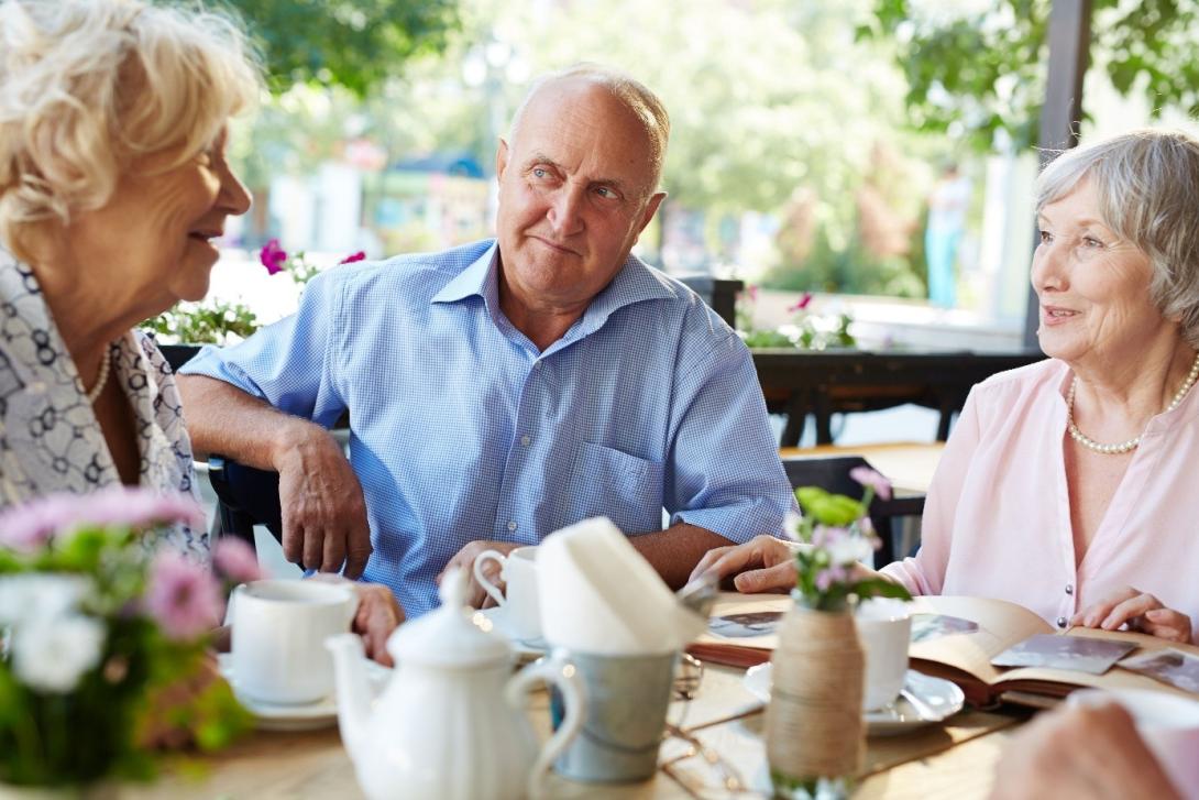 oudere man en dames aan de babbel- en koffietafel