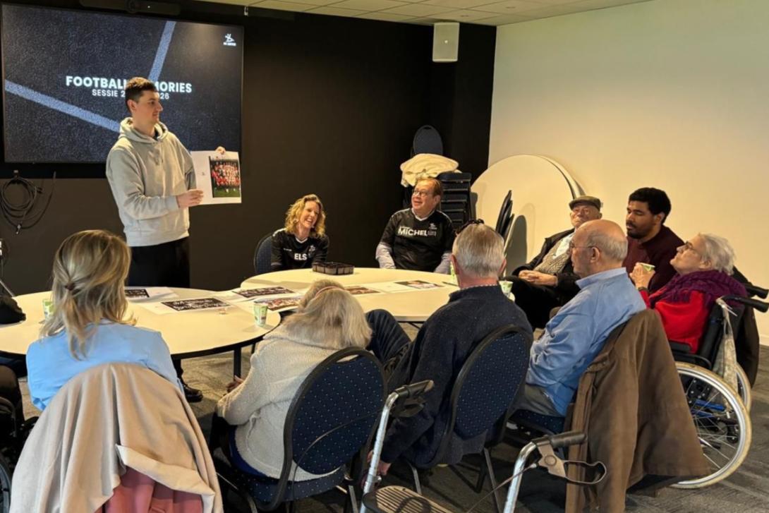 Medewerker OH Leuven toont geschiedenisdocument aan fans met dementie 