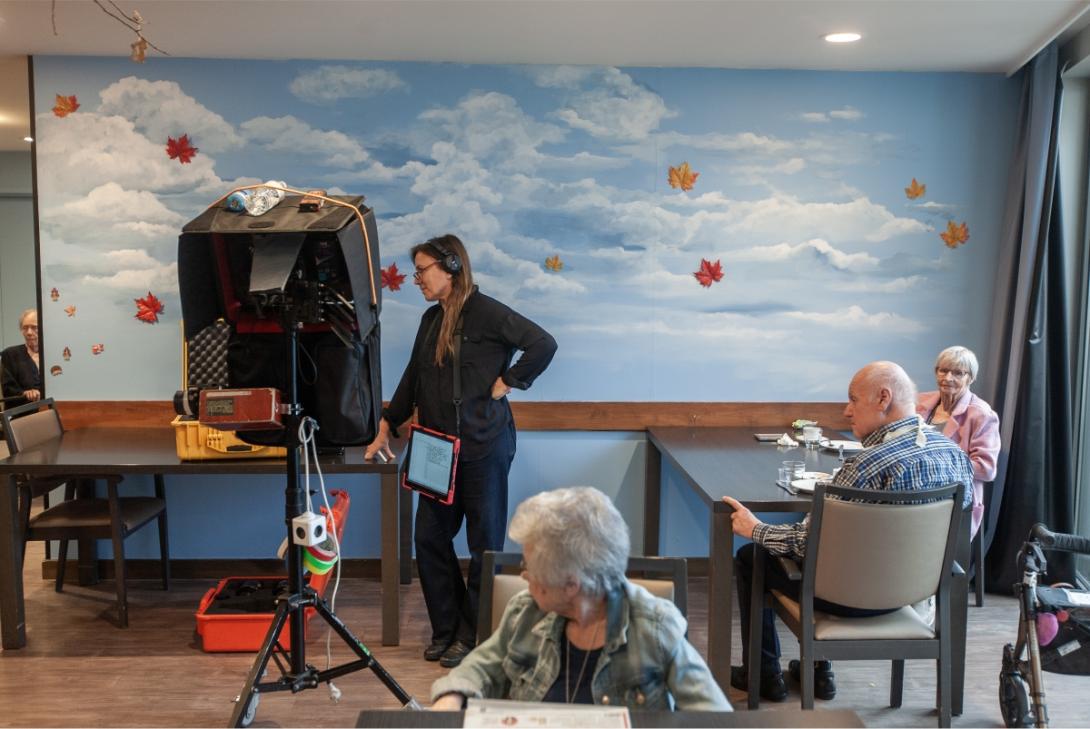 Sfeerbeeld met bewoners en camera tijdens opnames Zondag de Negenste
