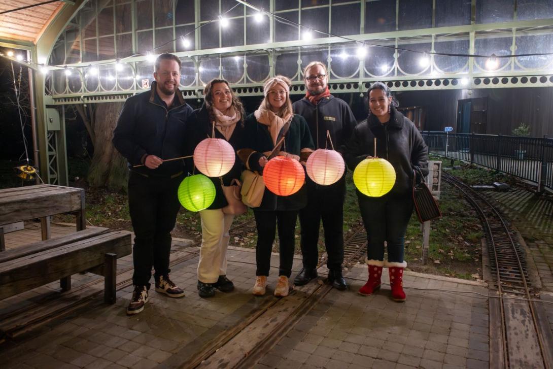 groepje wandelaars met lampionnen poseert in oude treinhal