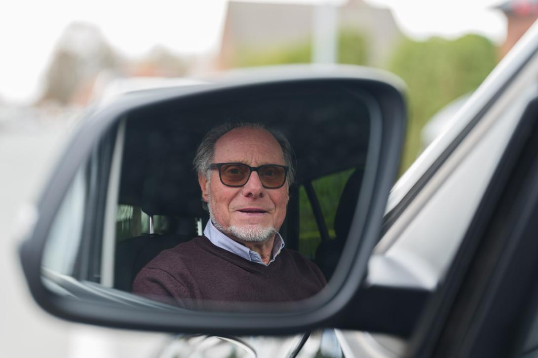 Bestuurder kijkt in linker achteruitkijkspiegel 