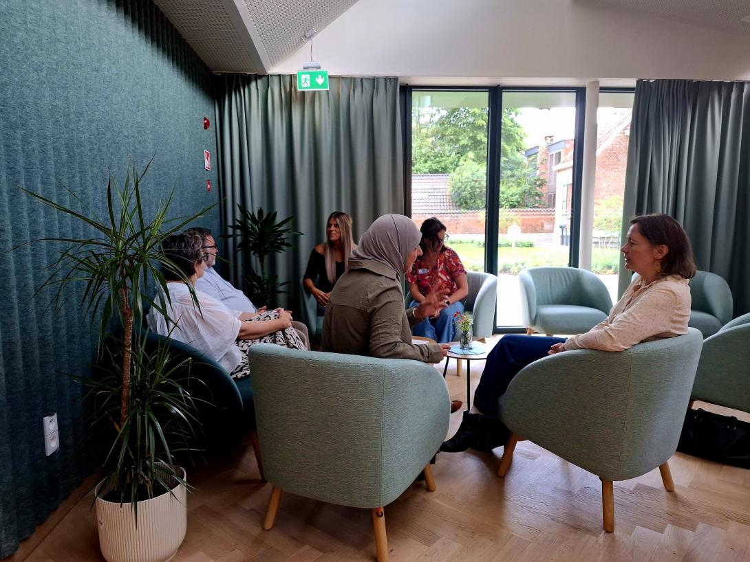 Mensen in comfortabele stoelen en ruimte spreken met elkaar in 