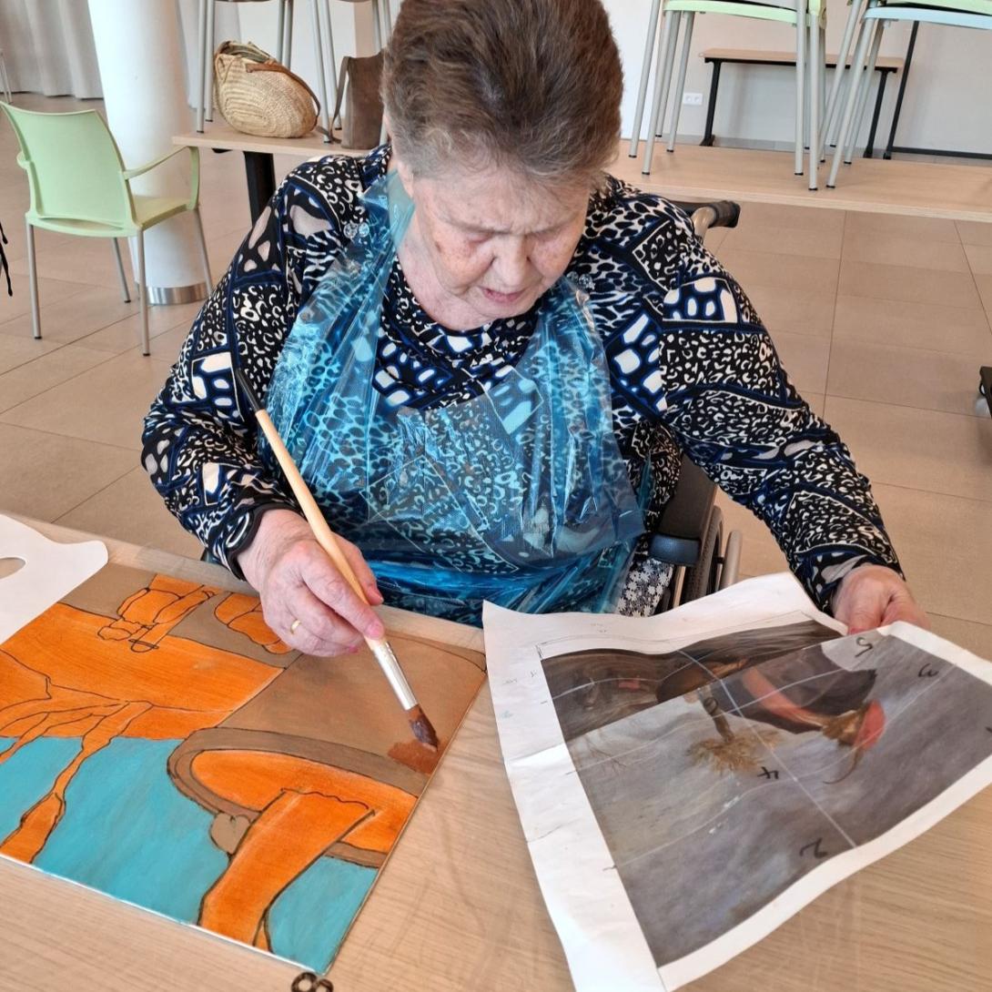 oudere dame is geconcentreerd aan het schilderen