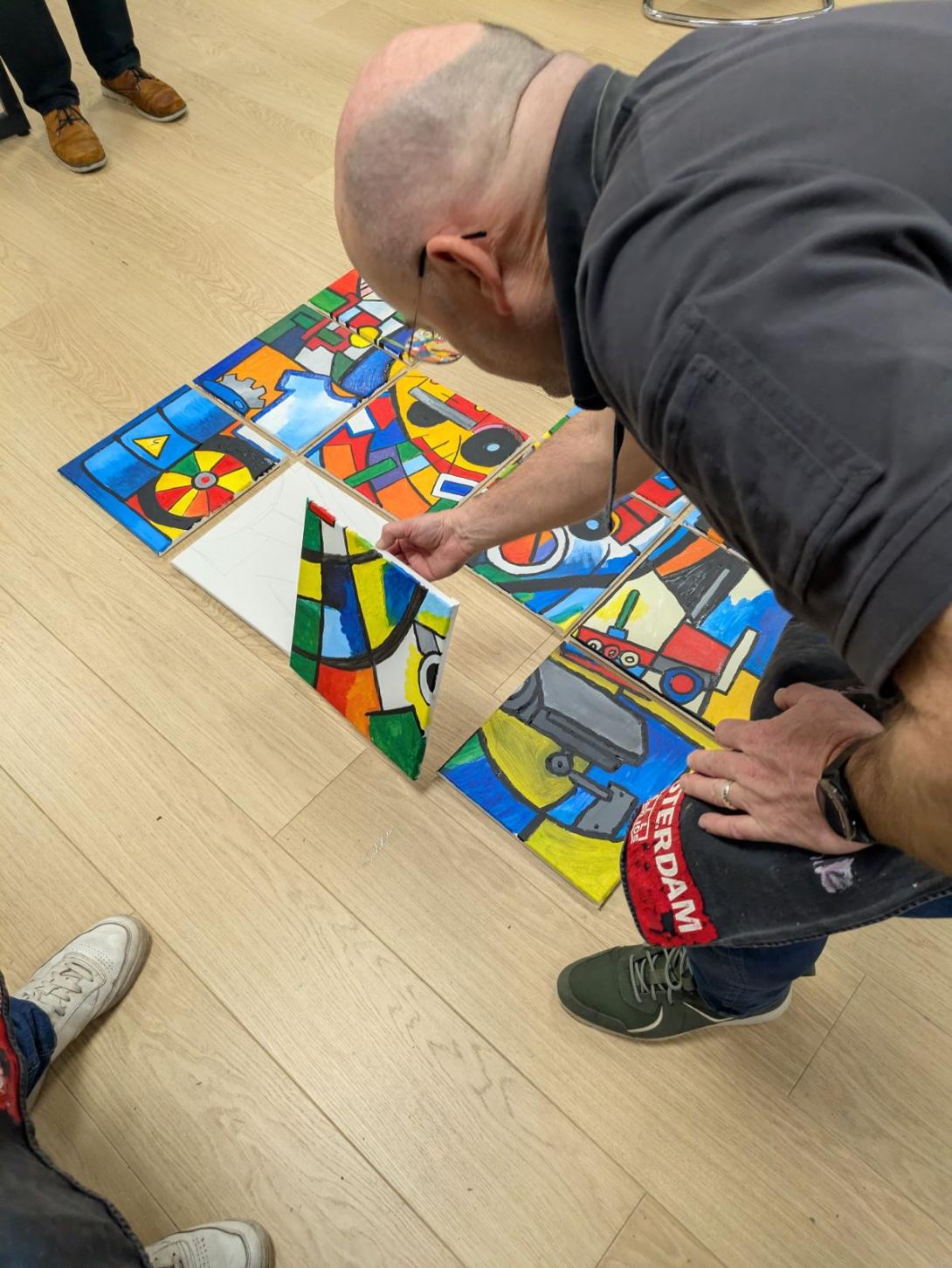 man legt puzzelstuk van schilderij