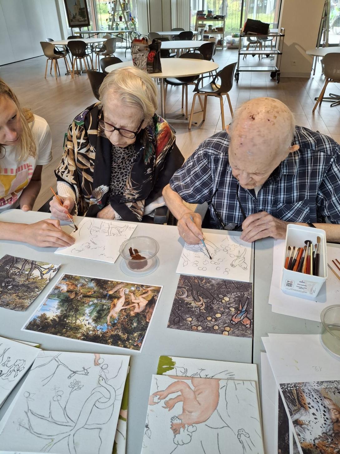 twee oudere mensen schilderen in het atelier van een woonzorgcentrum