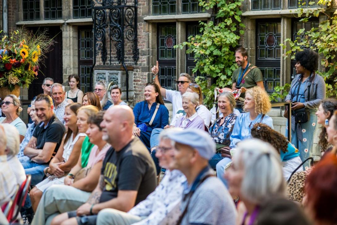 iemand in het publiek steekt zijn vinger op om te bieden